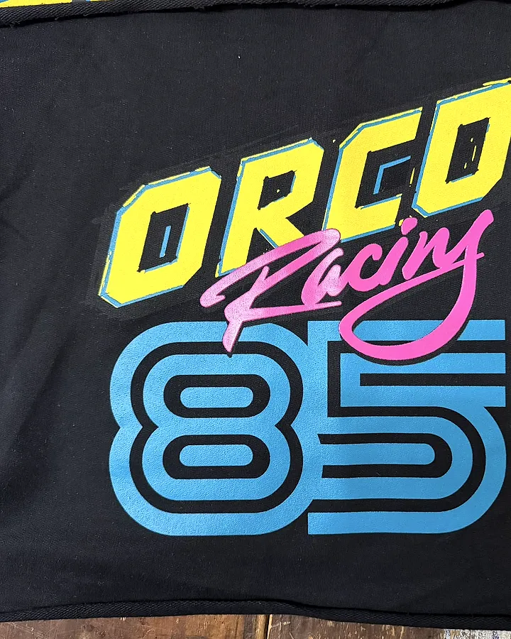 Remera negra con diseño a varios colores en relieve, serigrafía, marca de moda