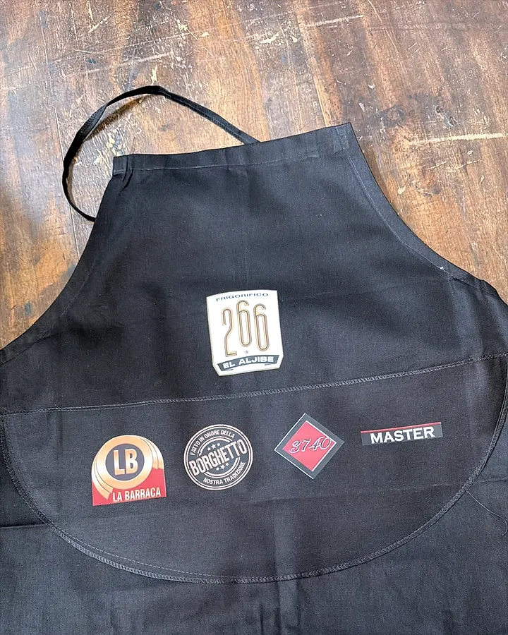 Delantal negro con logos a todo color, gastronomía